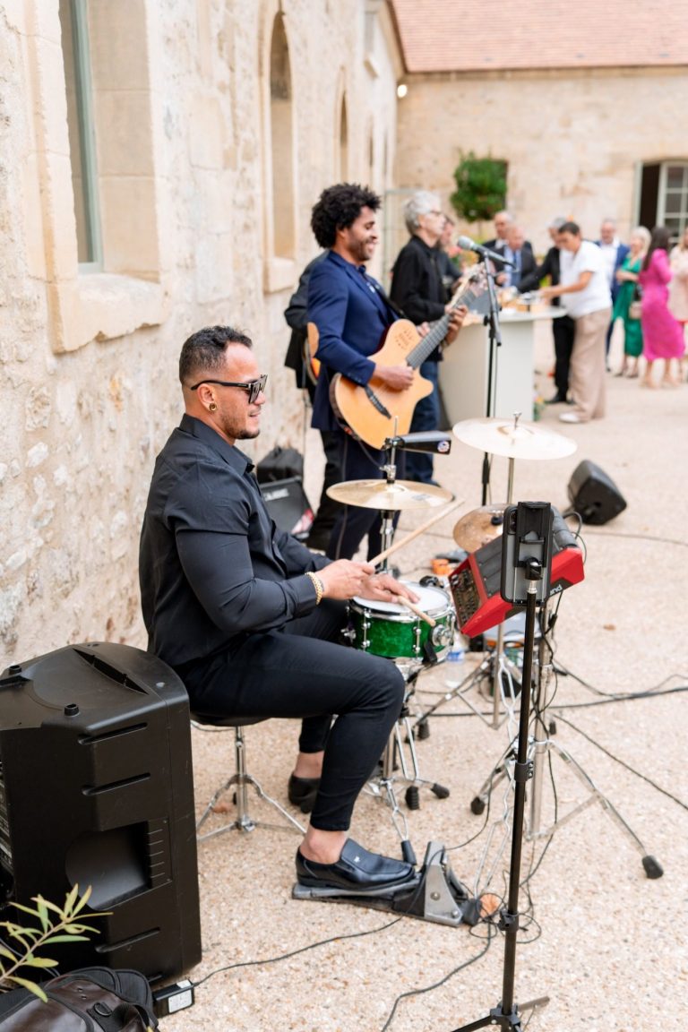 Groupe de musiciens jouant en plein air, instruments de musique en action.